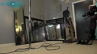 Brunette ballerina in black lingerie and hobble boots vacuums the house with long hair flowing.