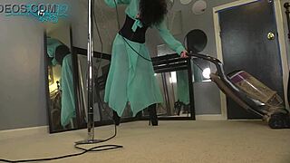 Brunette ballerina in black lingerie and hobble boots vacuums the house with long hair flowing.